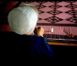 Amish woman working a quilt.