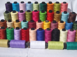 Assortment of industrially produced cotton threads.