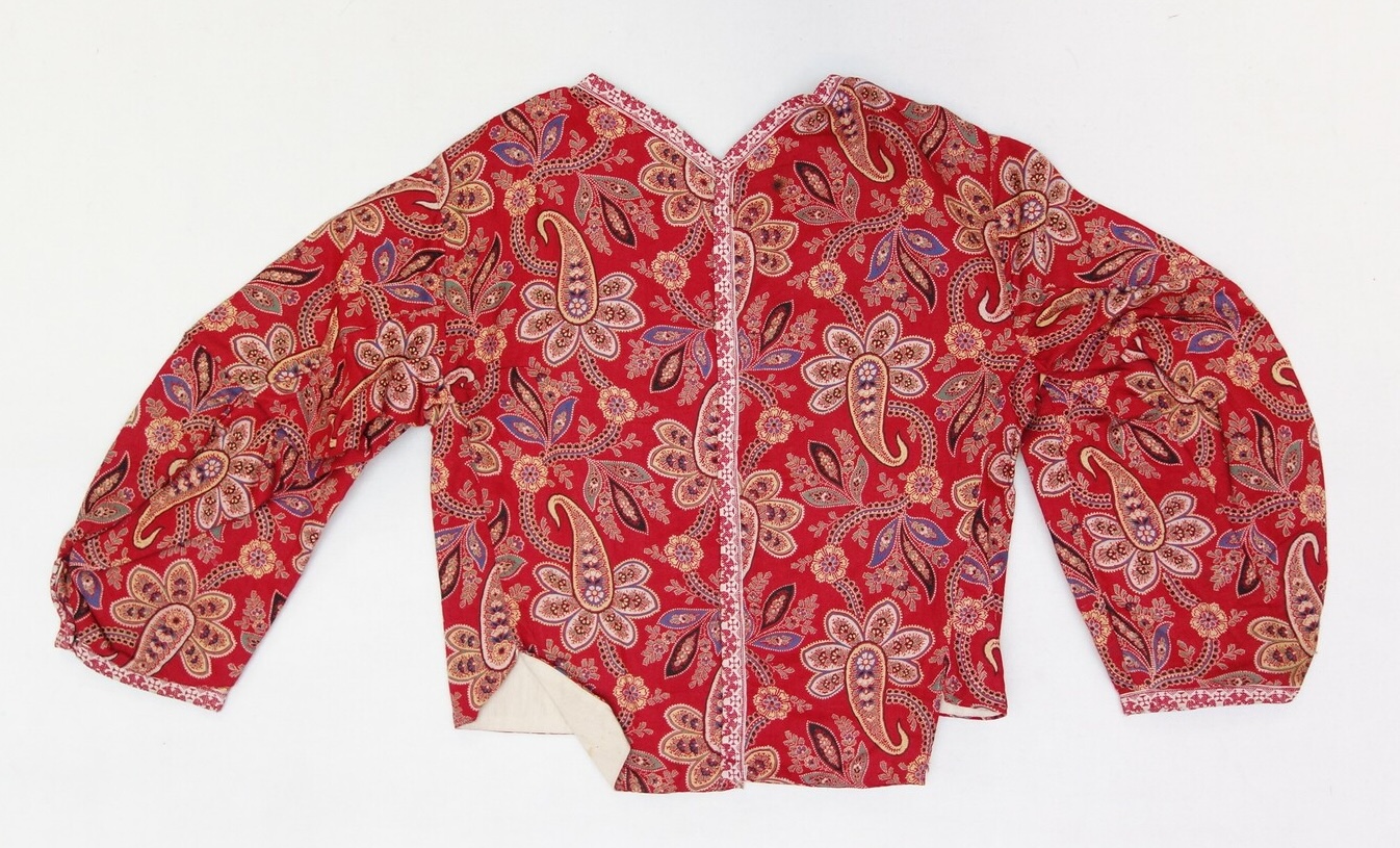 A jacket made from a red cotton cloth decorated with a multi-coloured floral and paisley pattern. From the island of Marken, The Netherlands, 1937 (TRC 2007.0525c).
