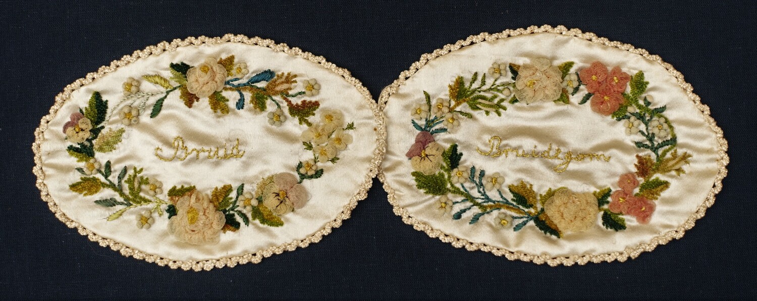 Two of the four early 19th century pads placed within a cardboard box, with the words 'bruid' and 'bruidegom' (bride and groom) (TRC 2014.1060c
