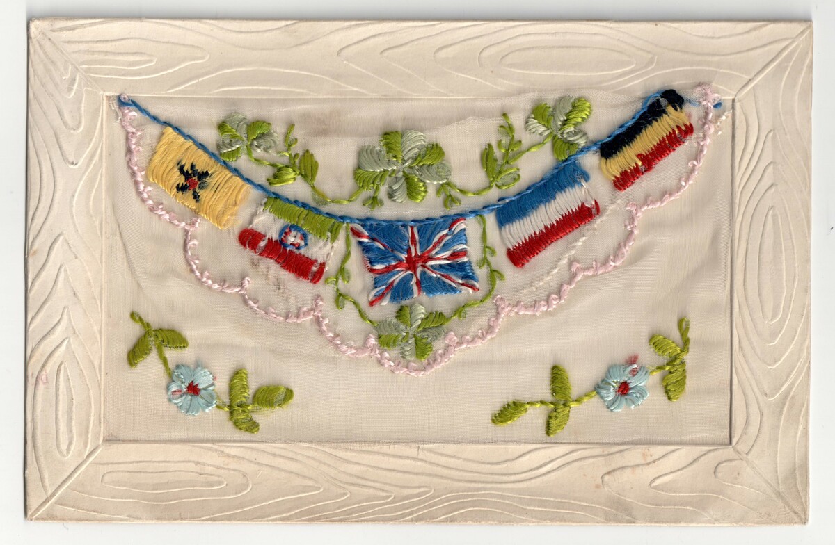 Machine embroidered postcard from the First World War, with flags from various allied nations. The Belgian and the French flags to the right are worked with horizontal, instead of vertical stripes (TRC 2015.0448).