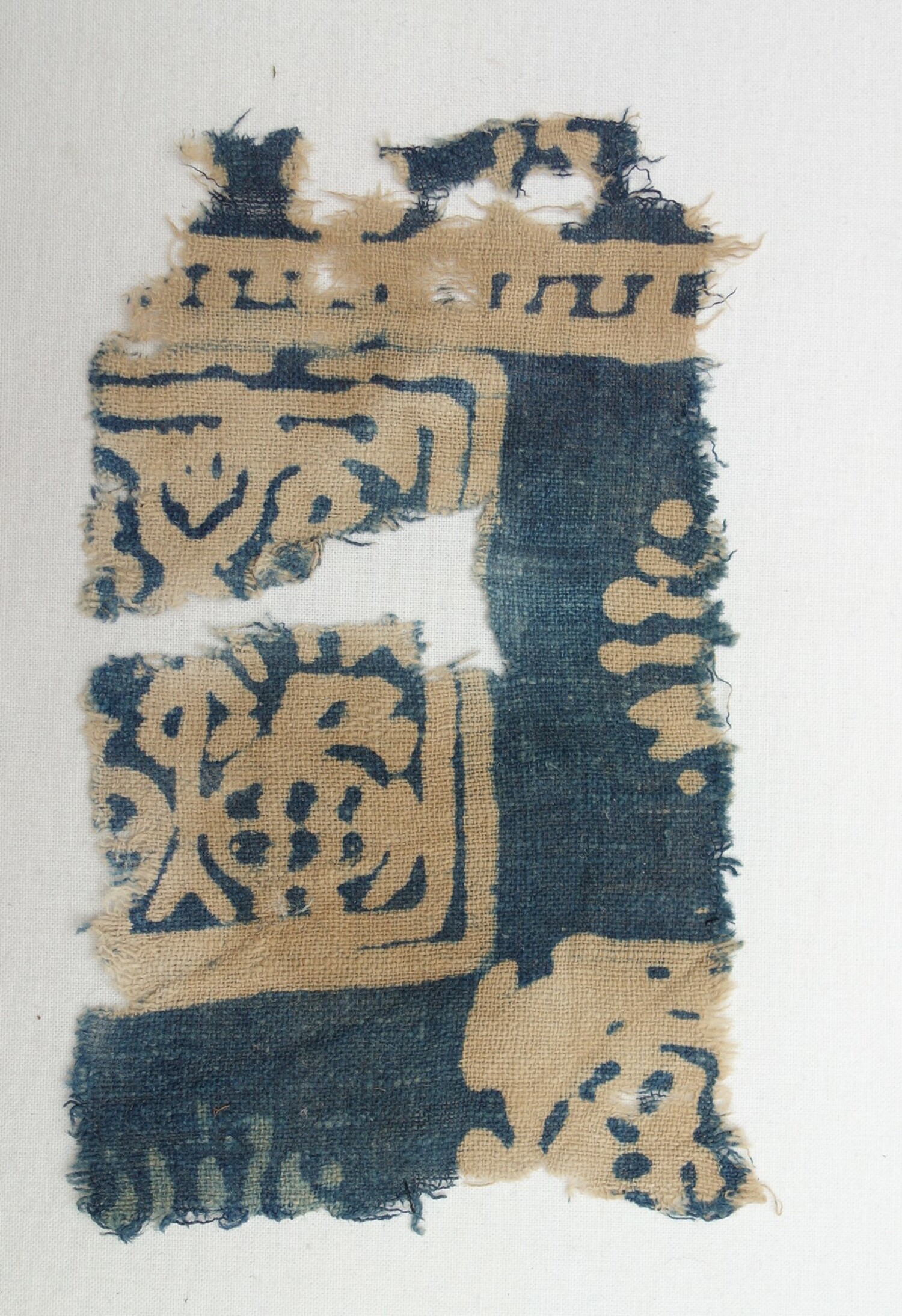 Fragment of a block-printed cotton cloth dyed with a resist technique. India, 14th cenury, excavataed in Quseir al-Qadim, Red Sea coast, Egypt (TRC 2020.0272).