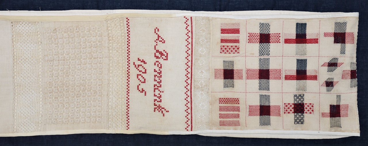 Detail with a date and the name of the embroiderer, of Dutch 'pronkstuk' needlework sampler (592 x 26 cm), made by Anna Berendina Bennink in 1905-1906 (TRC 2020.3535a). 