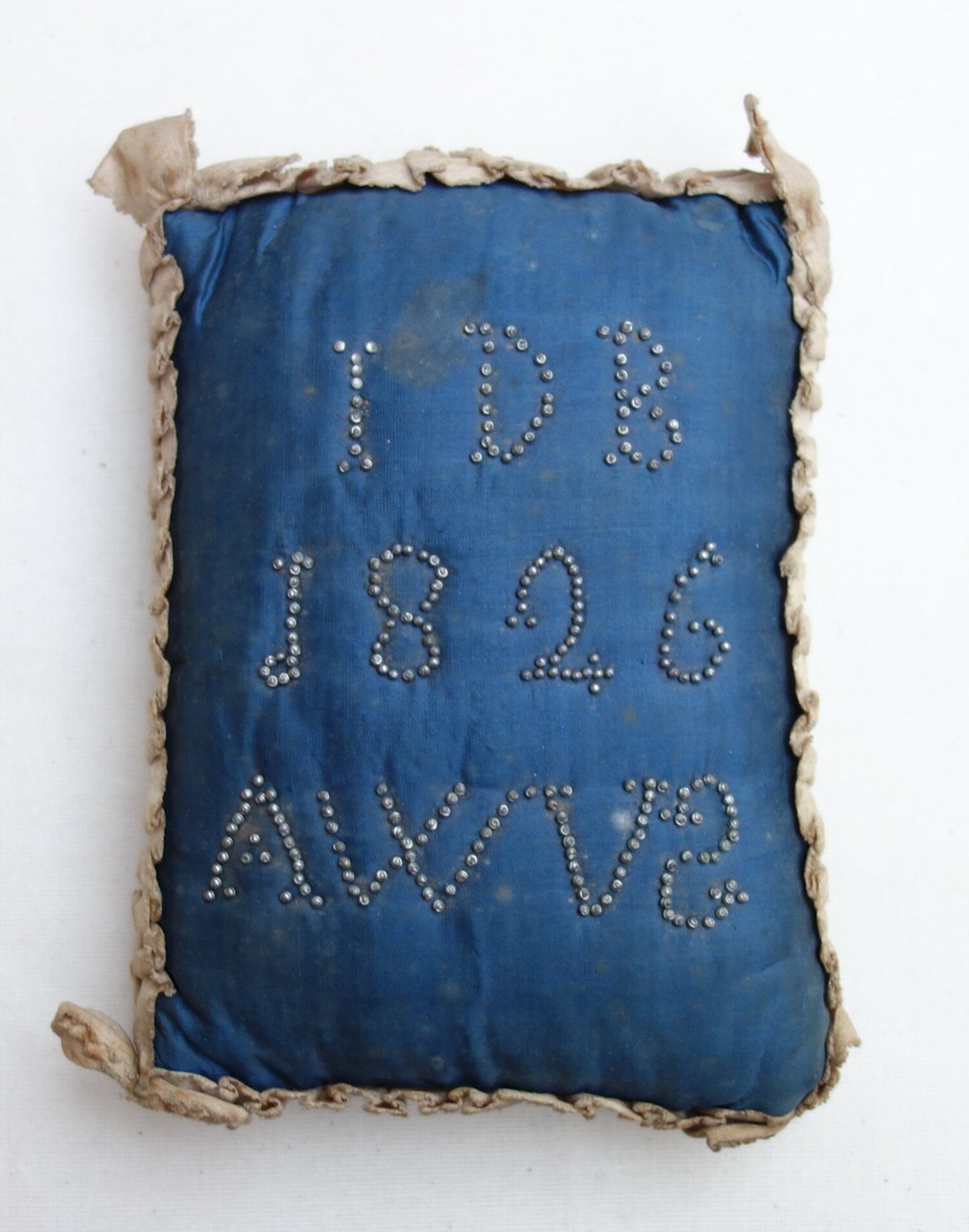 Pin cushion dating from 1826 from the Gouda region in The Netherlands. Initials (of the married couple?) and the date are indicated by pin heads (TRC 2020.4732a).