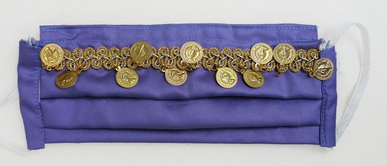 Face mask with a line of coloured spiral braid and costume coins, made by Nahla Faray, Amsterdam, for the face mask competition organised by The World Makers Foundation and others, Amsterdam, 2020. TRC 2021.1760.