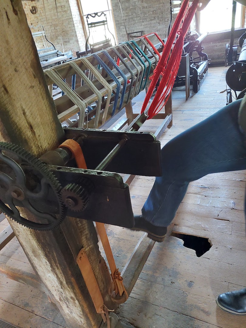 A guide demonstrates how skeins were made. The hole in the floor was made by a worker repeatedly pressing the treadle to twist the yarn. Photo by Shelley Anderson