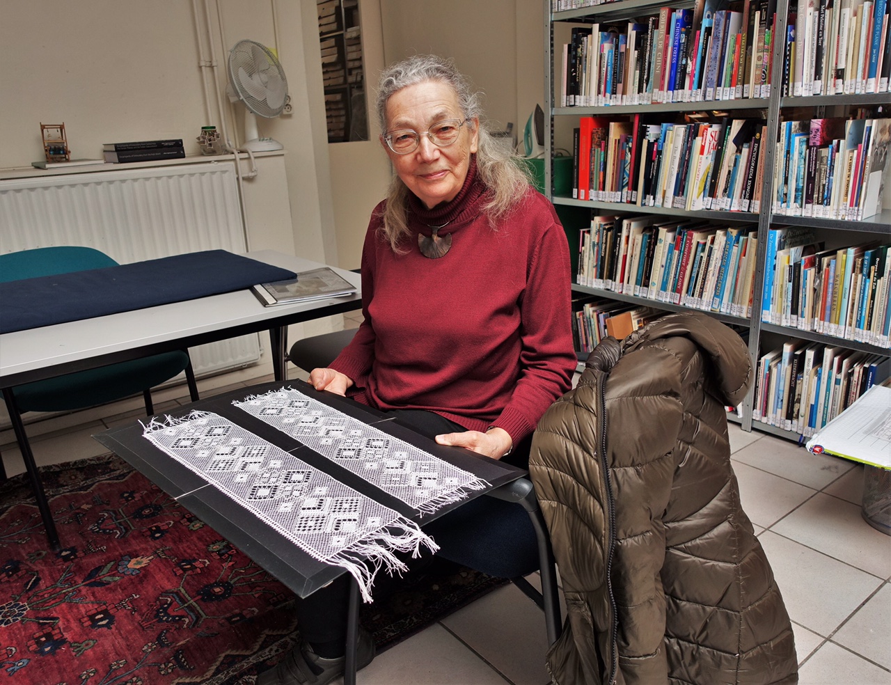 Mrs Bettie Stijnman showing the two reconstructions that she made of the 's Gravenmoer lace flounce on the Rijnland cap (TRC 2021.2446).