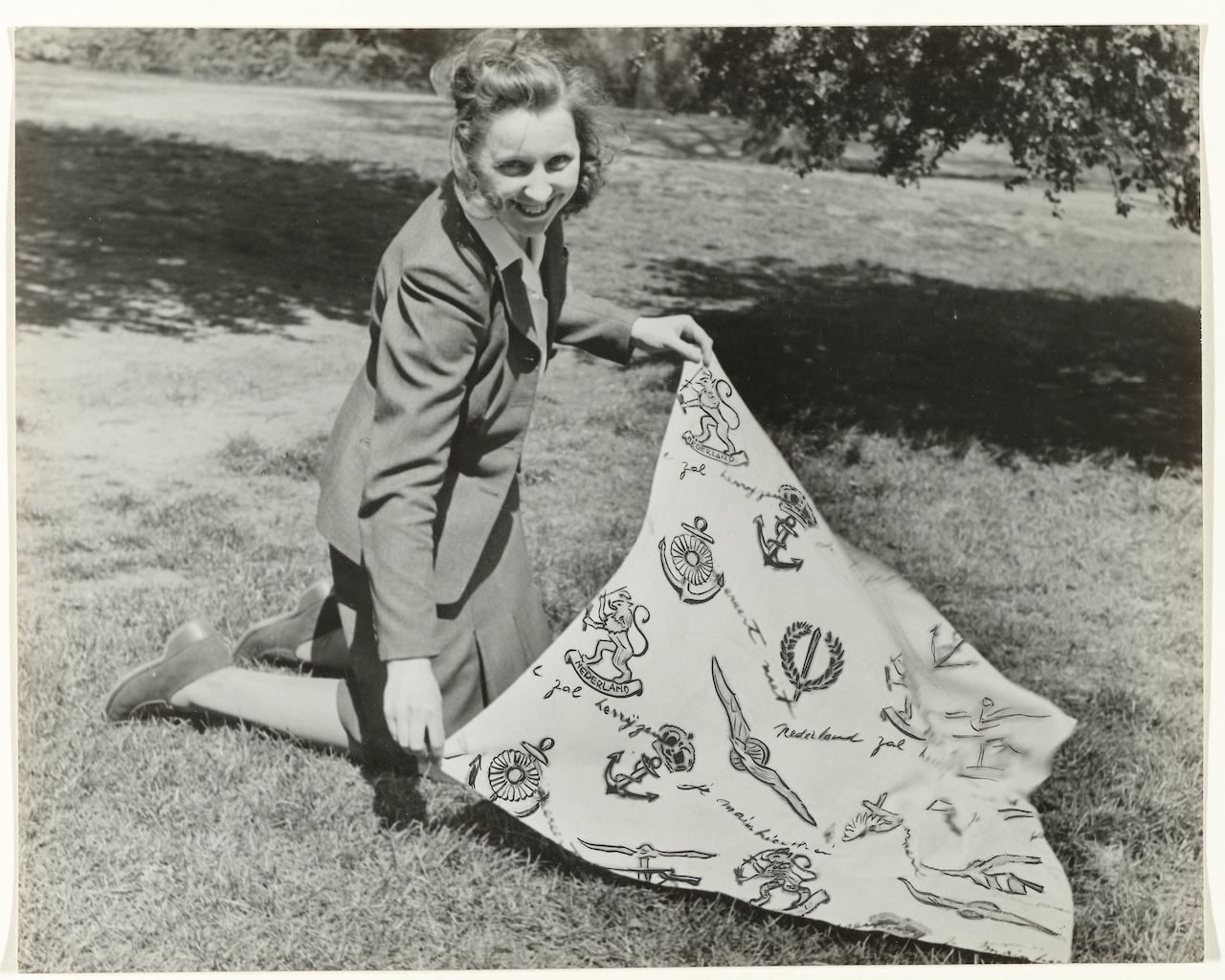 Photograph of a woman displaying the Red Cross scarf designed by Prince Bernhard  (Rijksmuseum, Amsterdam, NG-1988-9-20).