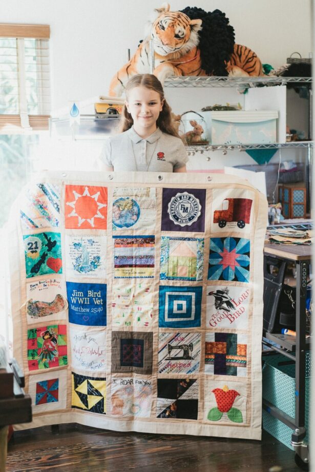 Madeleine Fugate holds up a panel of the Covid Memorial Quilt, which will be displayed in museums, hospitals, churches, schools and traveling exhibitions (WNV/Lisa Smith)