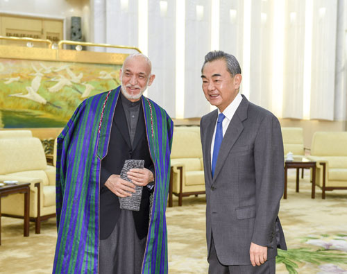 Former President Hamid Karzai of Afghanistan with Foreign Minister Wang Yi of China, December 2019. Karzai is wearing the Uzbek-style chapan. He is holding a karakuli cap in his hands. Courtesy Ministry of Foreign Affairs, PRC.