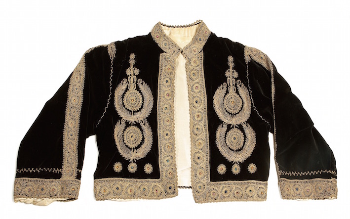 A Bethlehem jacket for a woman, based on a British military uniform jacket, complete with epaulettes and medals, worked in couching using gold thread with details in coloured silks (1920’s, TRC 2004.0120).