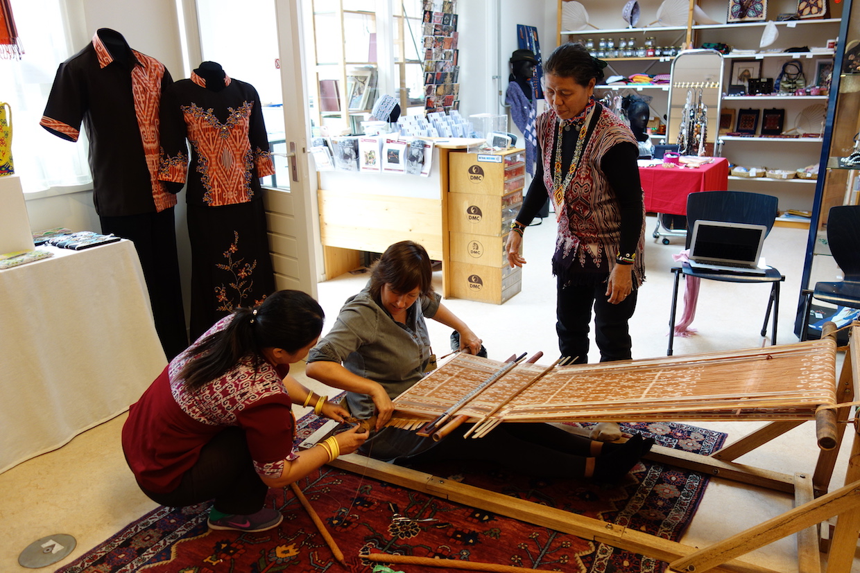 Participants to the ikat workshop having lessons on how to weave on a body-tension loom.